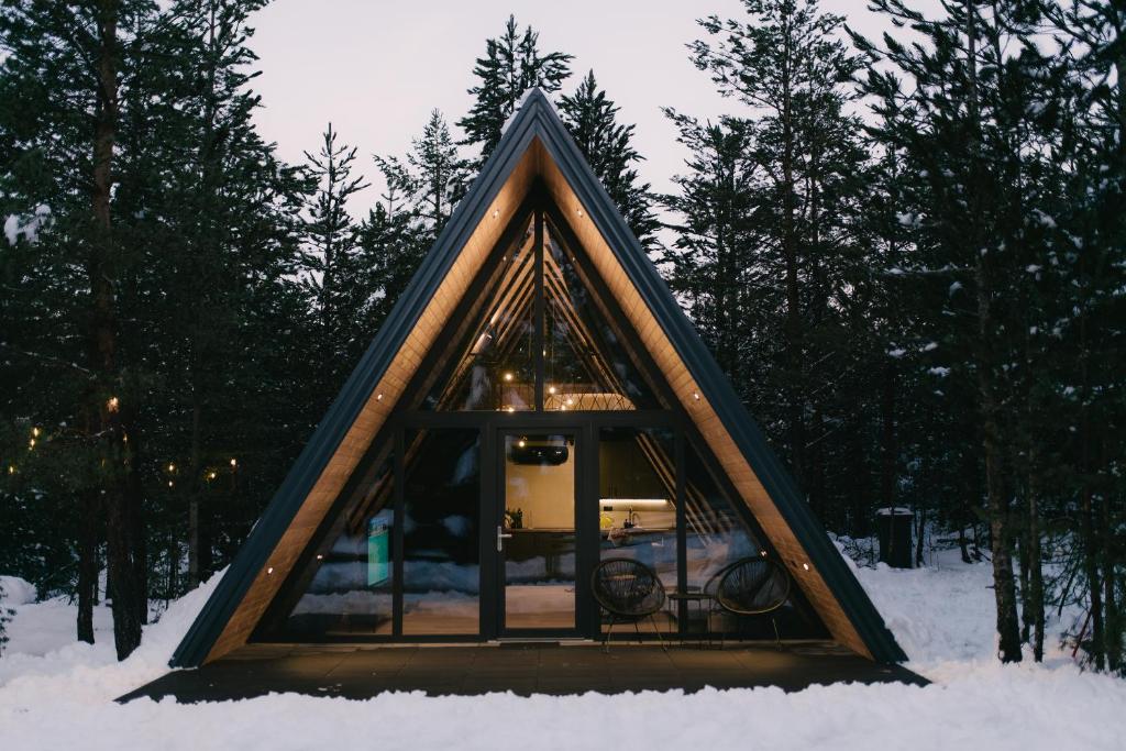 a small house with a window in the snow at Pinery Blidinje A-Frame House in Blidinje