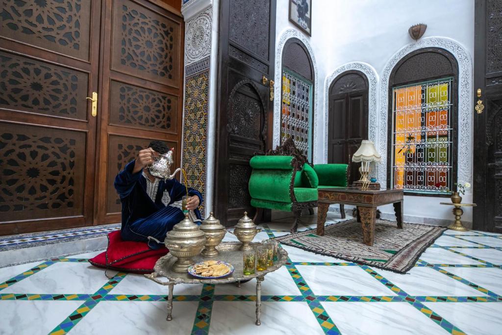 a woman sitting on the floor in a room at Palais Chahd Luxury in Fez