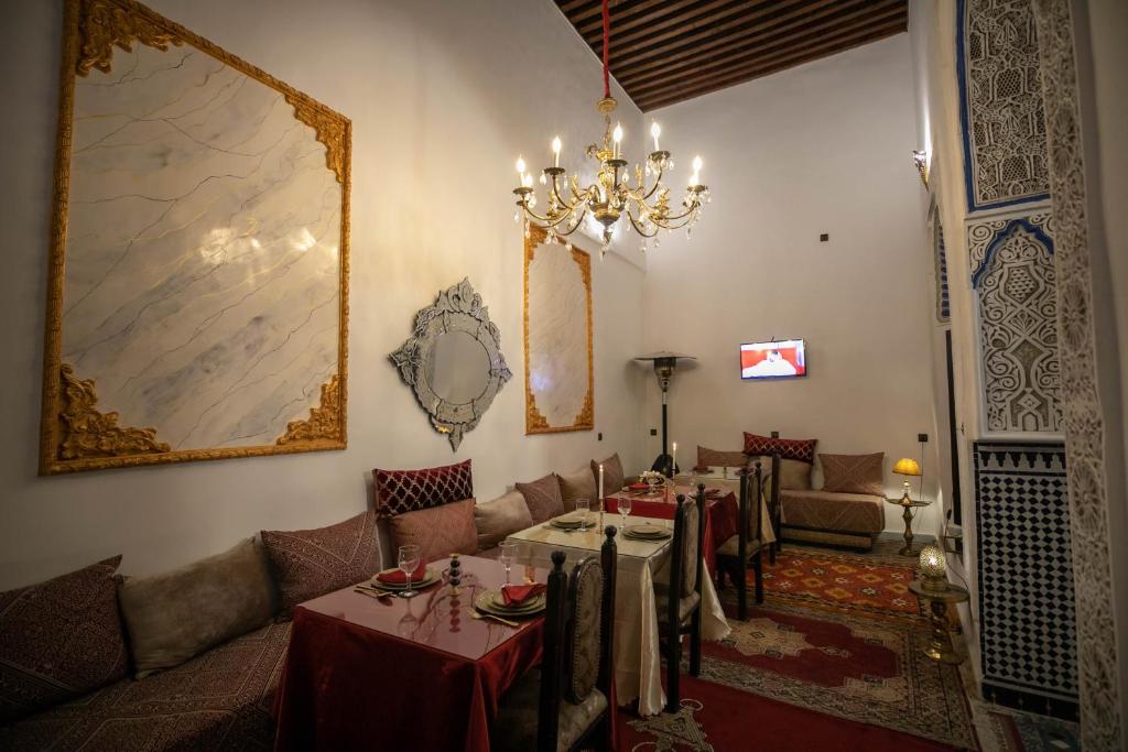 a dining room with a table and a chandelier at Palais Chahd Luxury in Fez