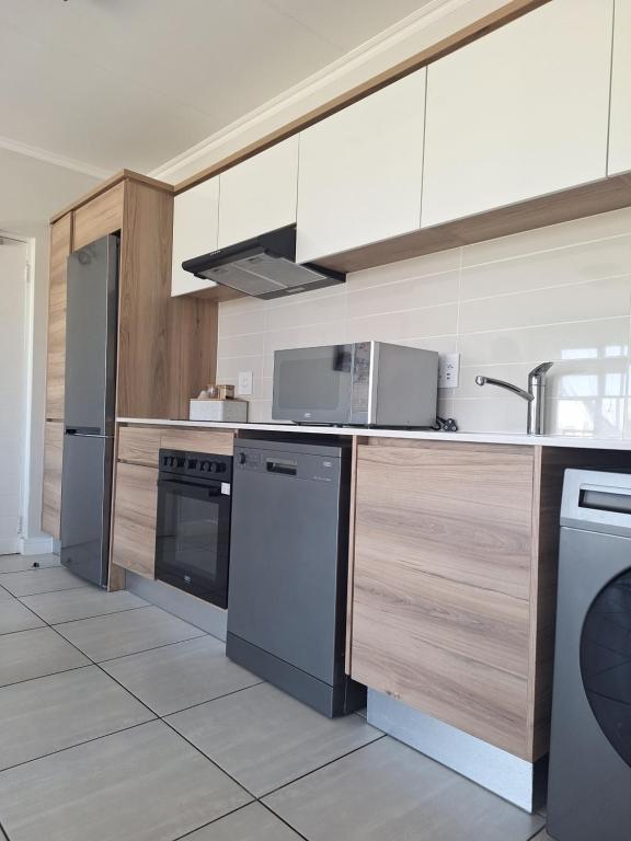 a kitchen with a sink and a dishwasher at Prunell in midrand in Midrand