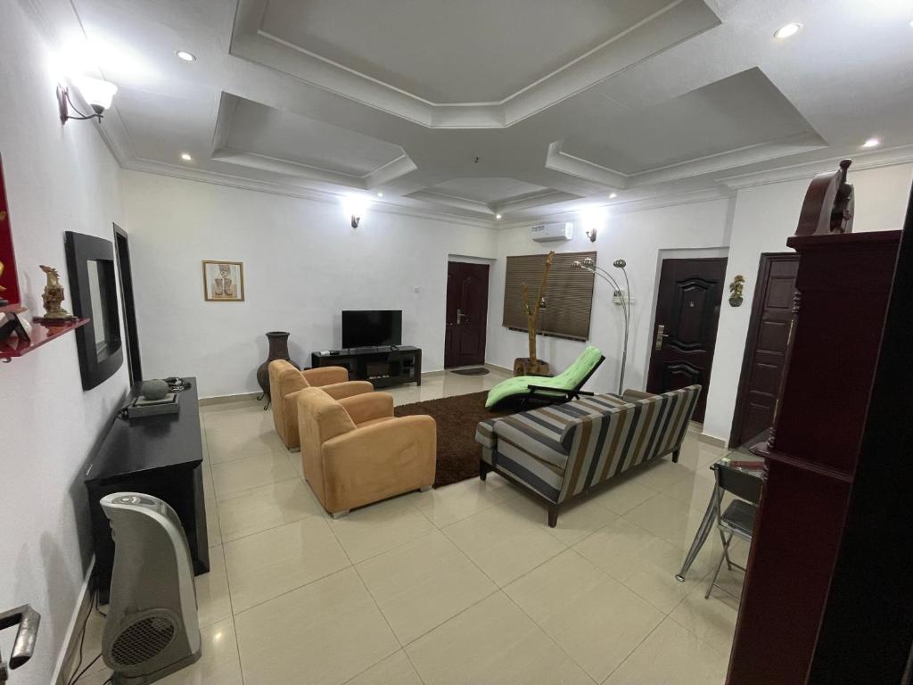 a living room with couches and chairs and a television at Joda’s apartment in Lagos