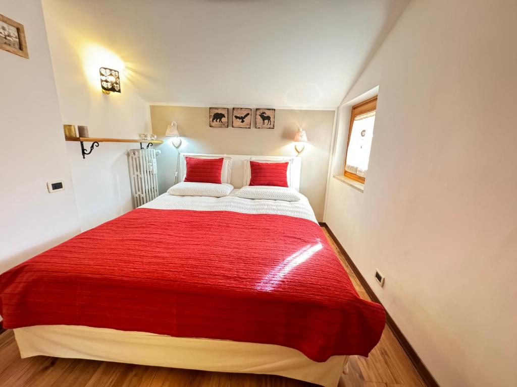 a red and white bed in a small room at Liuby Home in Sestriere