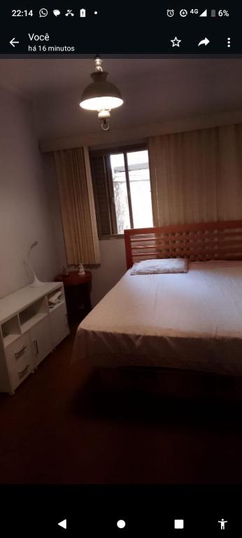 a bedroom with a large bed and a window at Mansão bairro nobre in Campinas