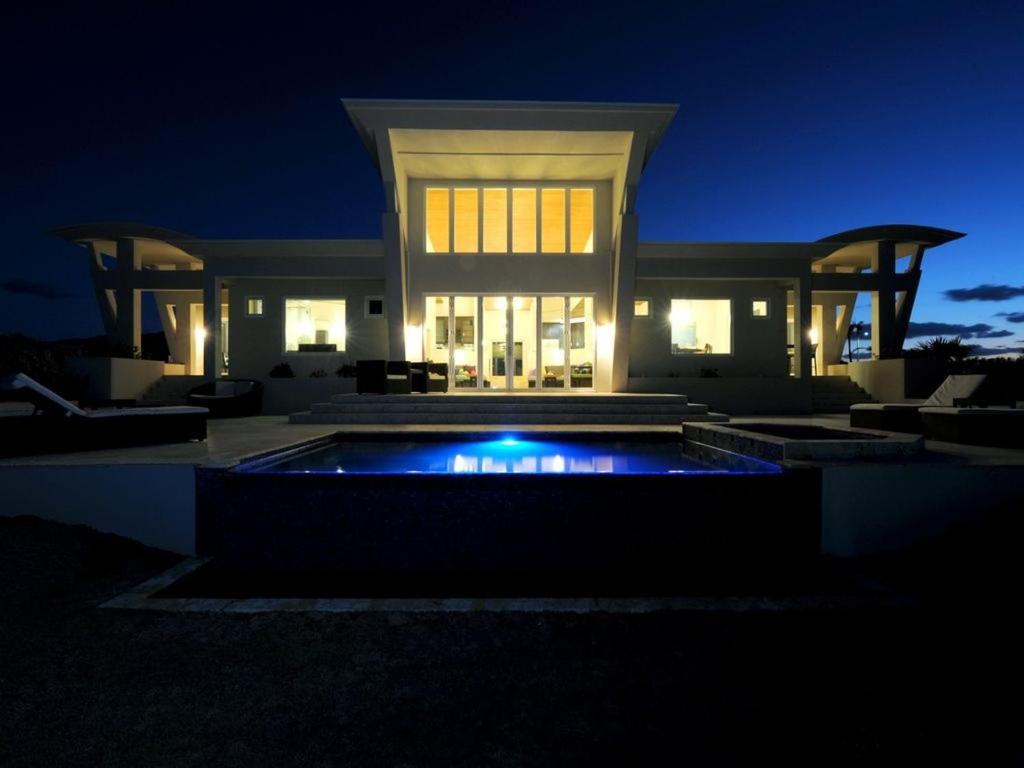 una grande casa con piscina di notte di Sky Beach Club Villa Waterfall 2 home a Governorʼs Harbour