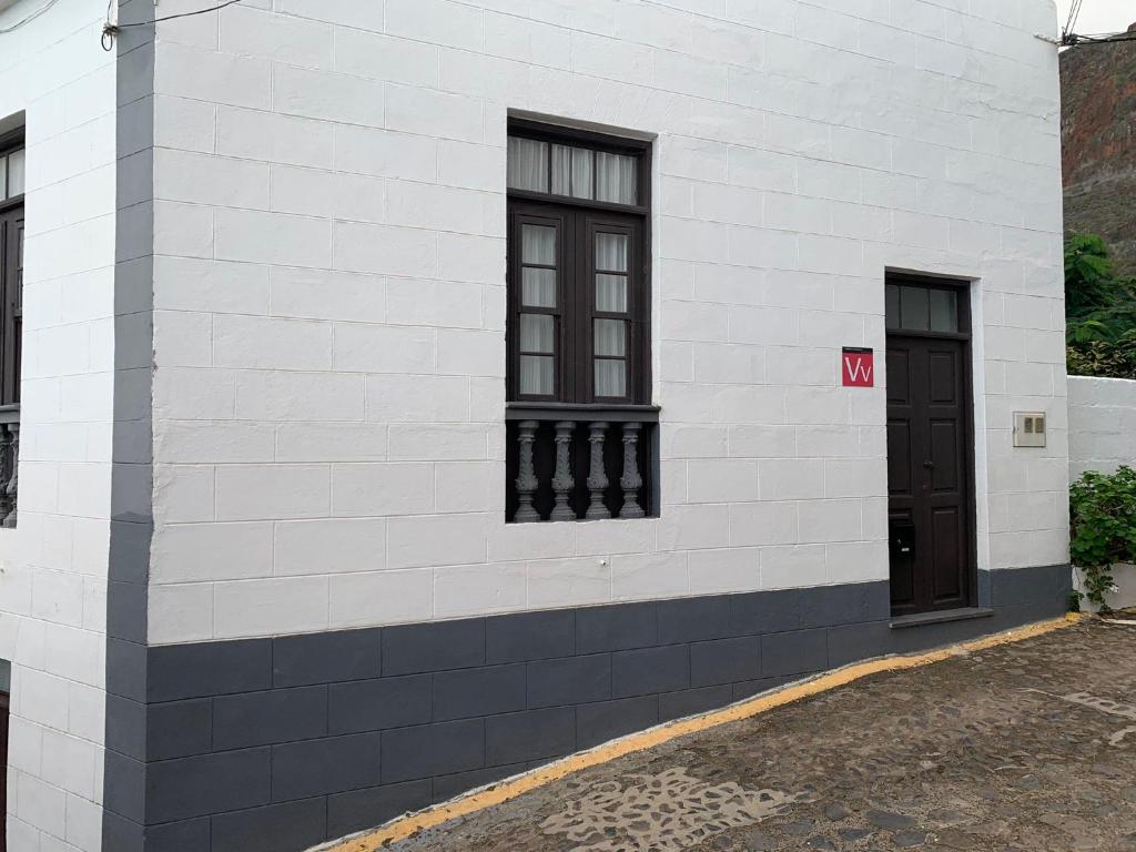 a white brick building with two windows and a door at Meriga in Agulo