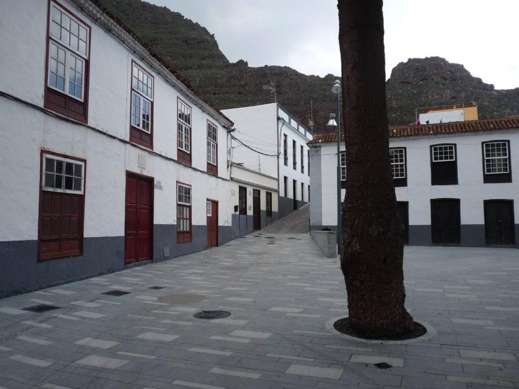 an empty street with white buildings and a tree at Meriga in Agulo