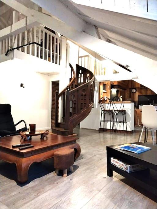 - un salon avec une table en bois et un escalier dans l'établissement Au Château Perché ~ Hypercentre ~ Vue Château, à Pau