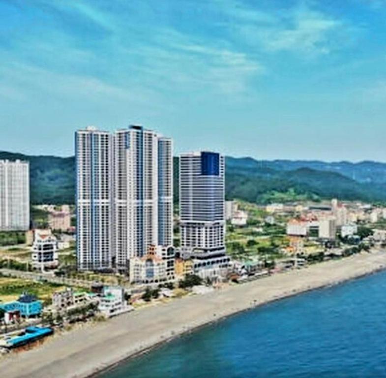 uma vista para uma praia com edifícios altos e para o oceano em Kangdong K Residence em Ulsan