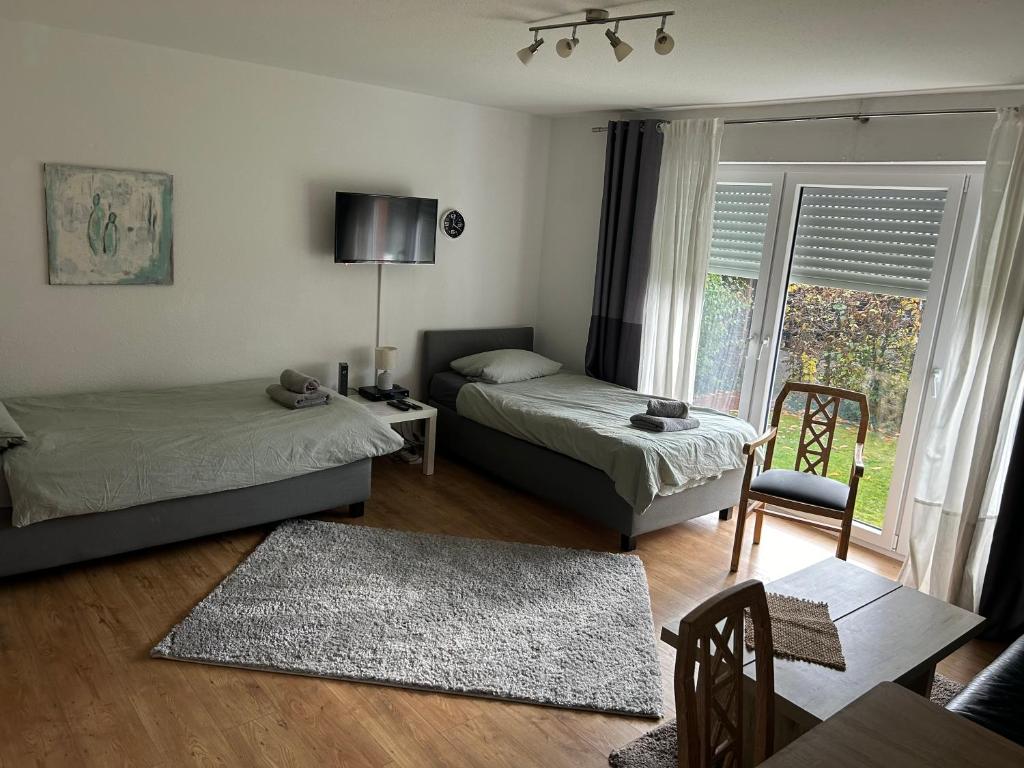 een woonkamer met 2 bedden en een raam bij Apartment am Kurpark in Bad Oeynhausen