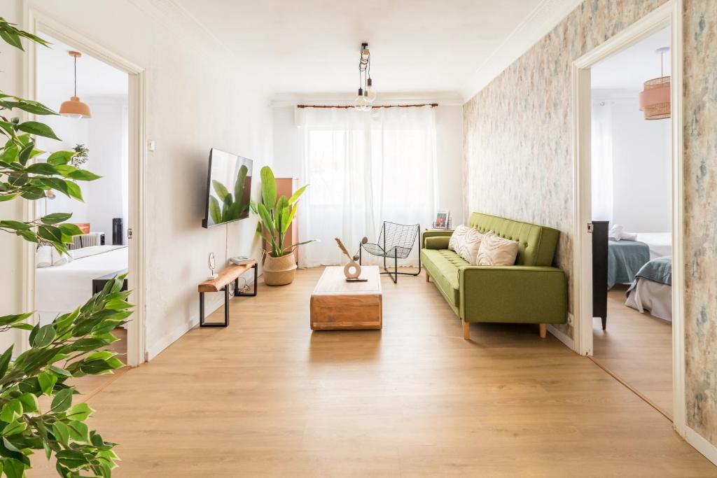sala de estar con sofá verde y mesa en Moderno apartamento céntrico en Santander
