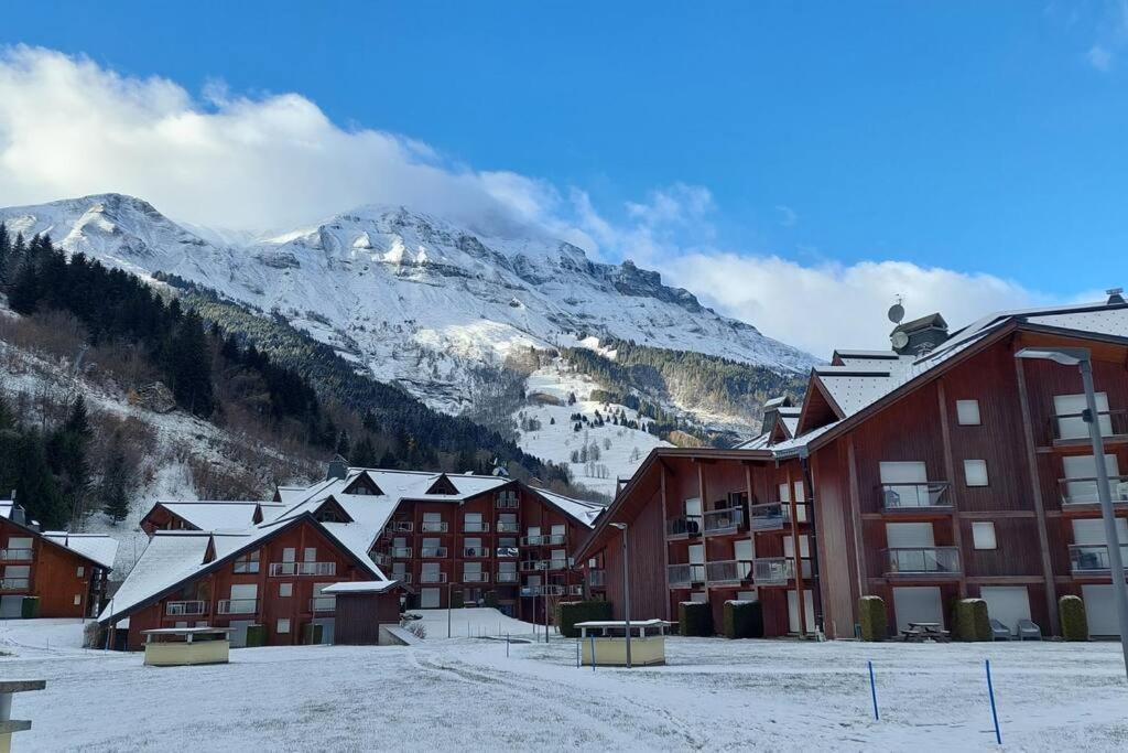 a group of buildings in the snow with a mountain at Studio au pied des remontées/wifi/smart TV/parking in Les Contamines-Montjoie