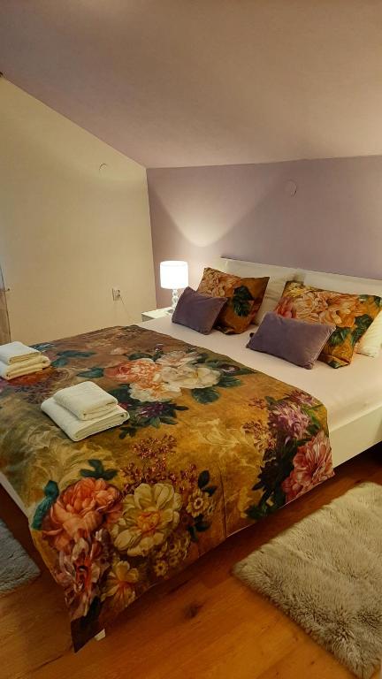 Apartman Mibel في زغرب: غرفة نوم بسريرين مع بطانية ورد