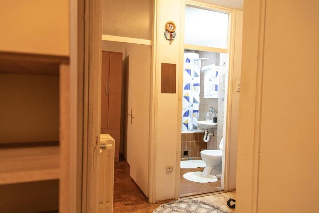 a bathroom with a white toilet and a sink at Apartman TWO 