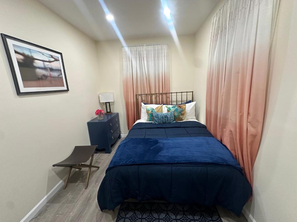Schlafzimmer mit einem Bett mit blauer Decke in der Unterkunft Upscale Super LUX Private 2br Near NYC in New Rochelle