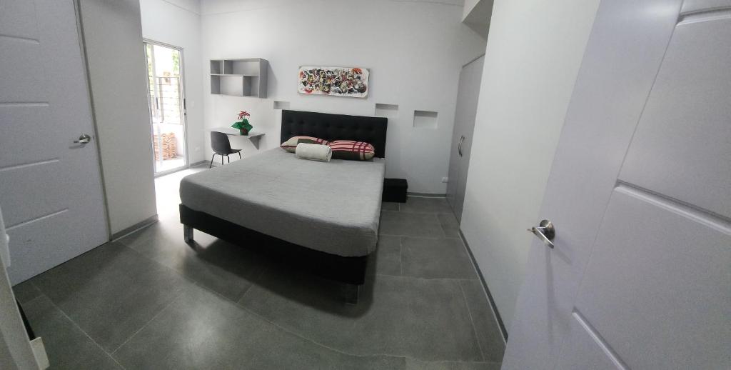 1 dormitorio con 1 cama en una habitación blanca en Casa Mariposa, en Herradura