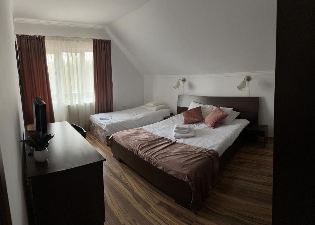 a hotel room with two beds and a desk at Vila Man in Sovata
