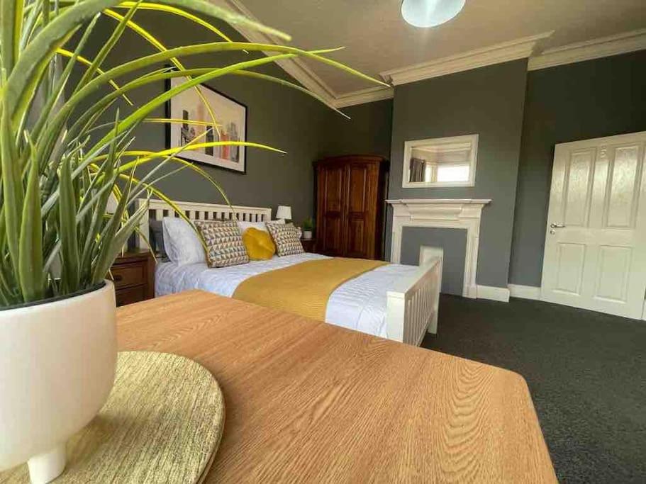 Sleightholme的住宿－Serviced Apartment- 1 Bed-Next To Train Station，一间卧室配有一张床和一张带盆栽的桌子