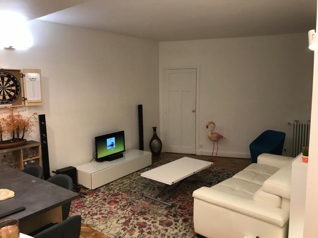 a living room with a white couch and a tv at Cosy Appartement in Paris 15th - Convention Center in Paris