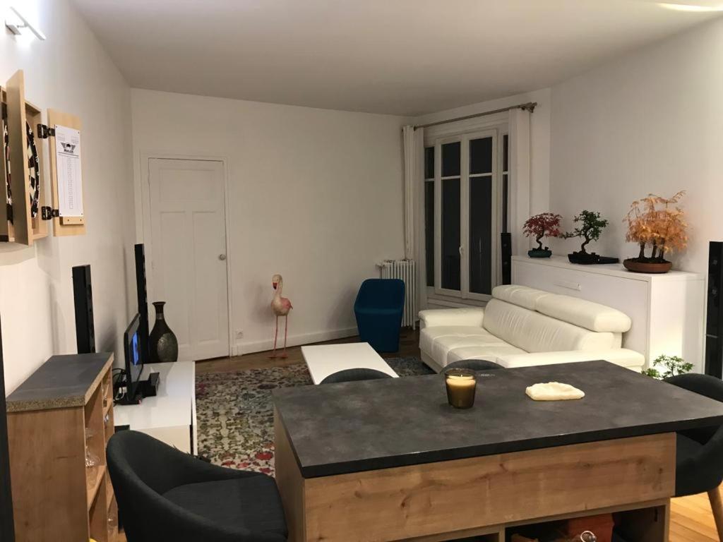 un salon avec un canapé et une table dans l'établissement Cosy Appartement in Paris 15th - Convention Center, à Paris