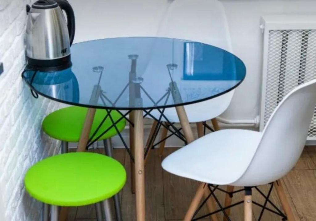 una mesa de cristal con 2 sillas verdes y una licuadora en VIP apart 746, en Tiflis