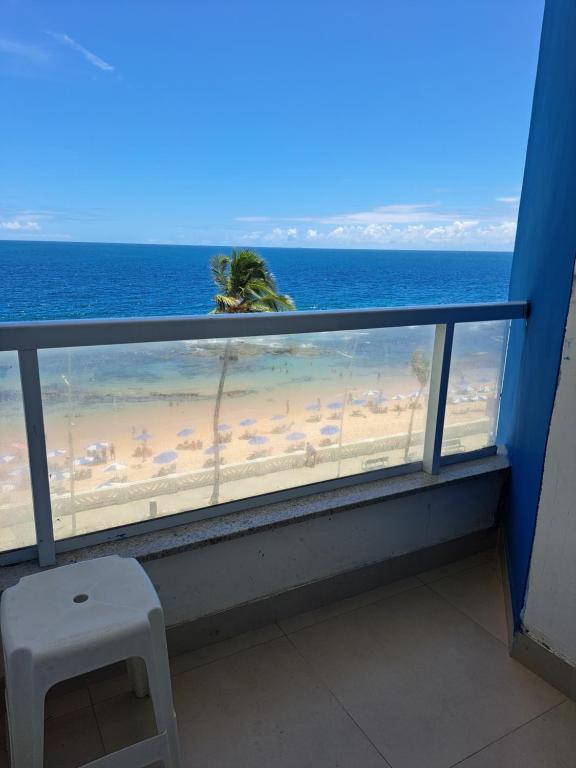 a view of the beach from a balcony with a chair at Bahia Flat 301 in Salvador