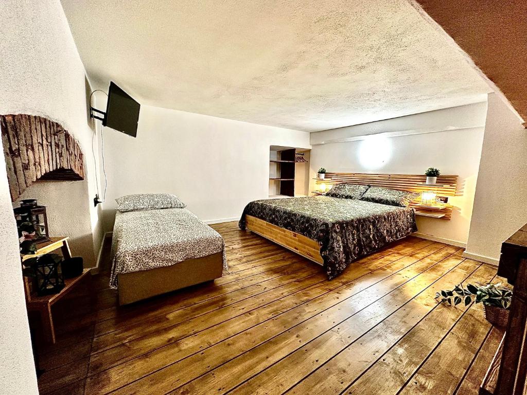 - une chambre avec 2 lits et du parquet dans l'établissement Loft La Lanterna, à Gênes