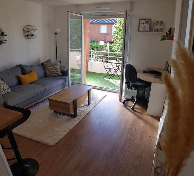 un salon avec un canapé bleu et une table dans l'établissement Résidence avec Parking et piscine - Proche airport, à Blagnac