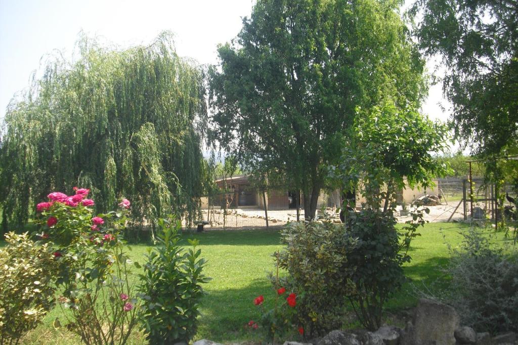 a garden with flowers and trees and a house at Le Poirier in Gordes