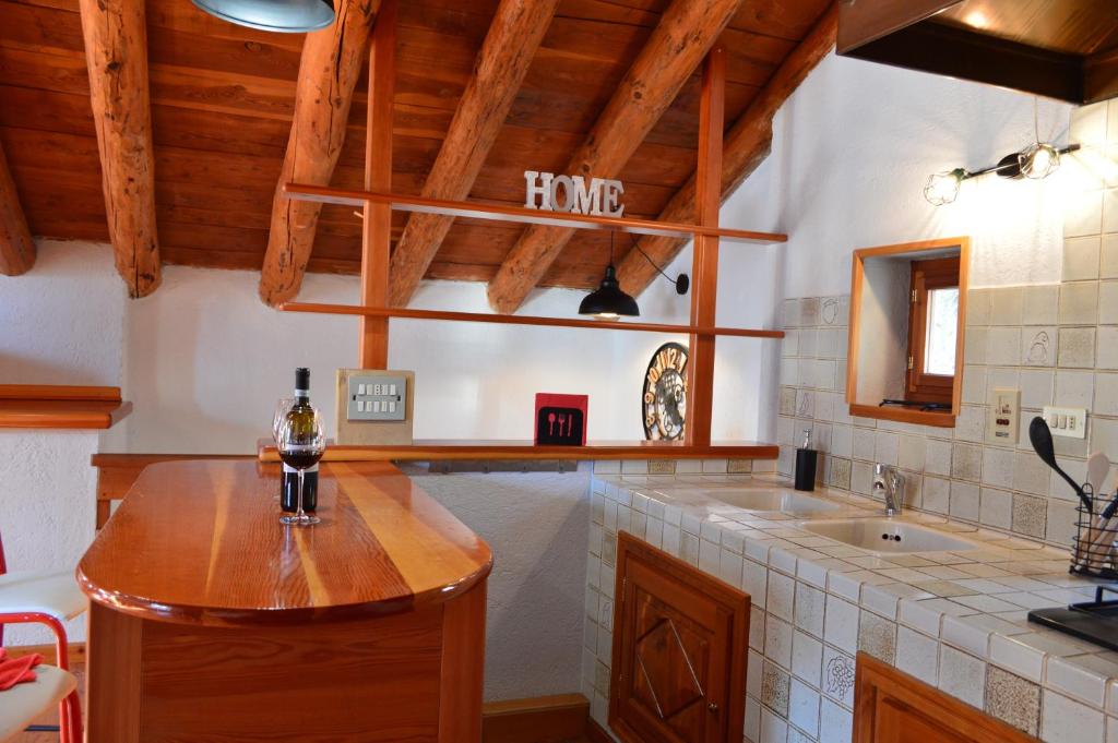 eine Küche mit einem Waschbecken und einer Holzdecke in der Unterkunft Maison Chez Les Roset in Baulen