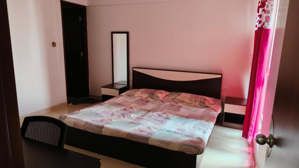um quarto com uma cama e uma parede rosa em The TEN 1 em Pune
