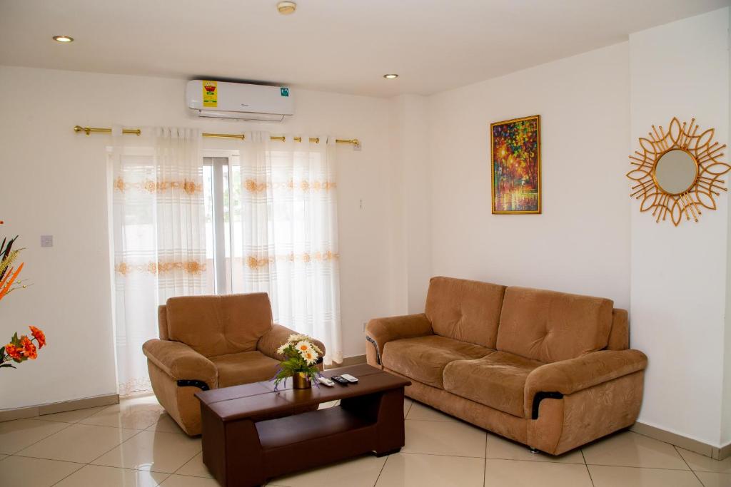 een woonkamer met 2 stoelen en een salontafel bij Luxury Home 3bed in Accra