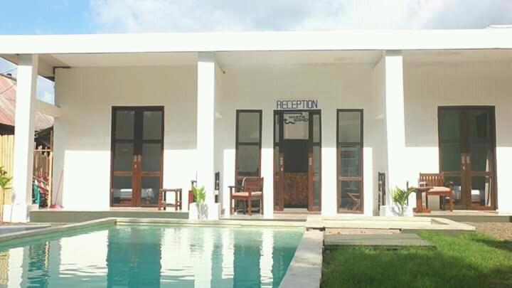 una casa con piscina frente a ella en WHITE SANDS RESORT en Gili Trawangan