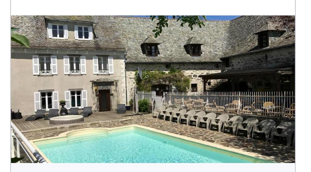 a swimming pool in front of a building at Bungalow de 3 chambres avec piscine partagee terrasse amenagee et wifi a Argences en Aubrac in Banes