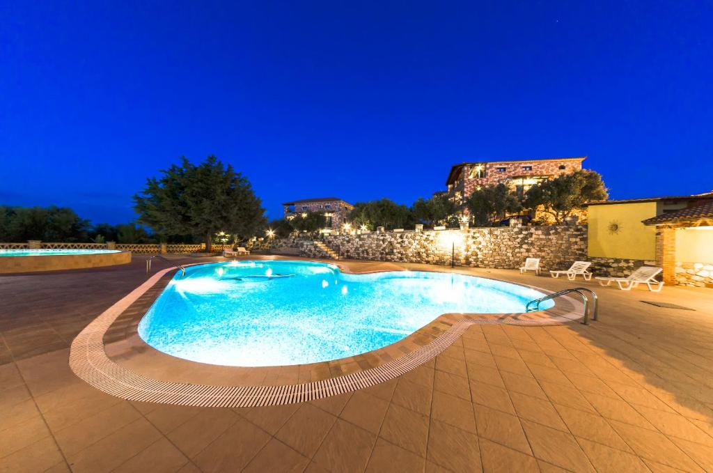 a swimming pool in a resort at night at Joanna's Stone Villas in Vasilikos