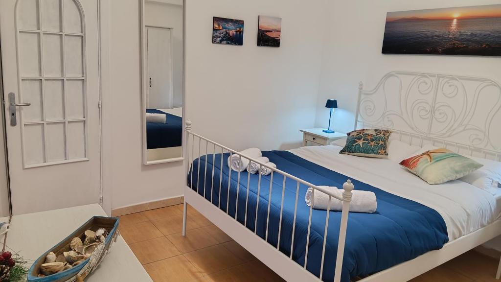 Schlafzimmer mit einem Bett mit blauer und weißer Bettwäsche in der Unterkunft DIMORA DANICLA in Neapel