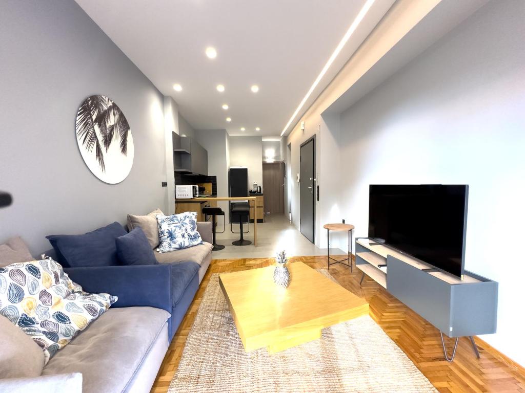 a living room with a blue couch and a flat screen tv at Nefertiti's Urban Luxury Kerameikos Athens 2br Industrial apt Balconies Netflix in Athens