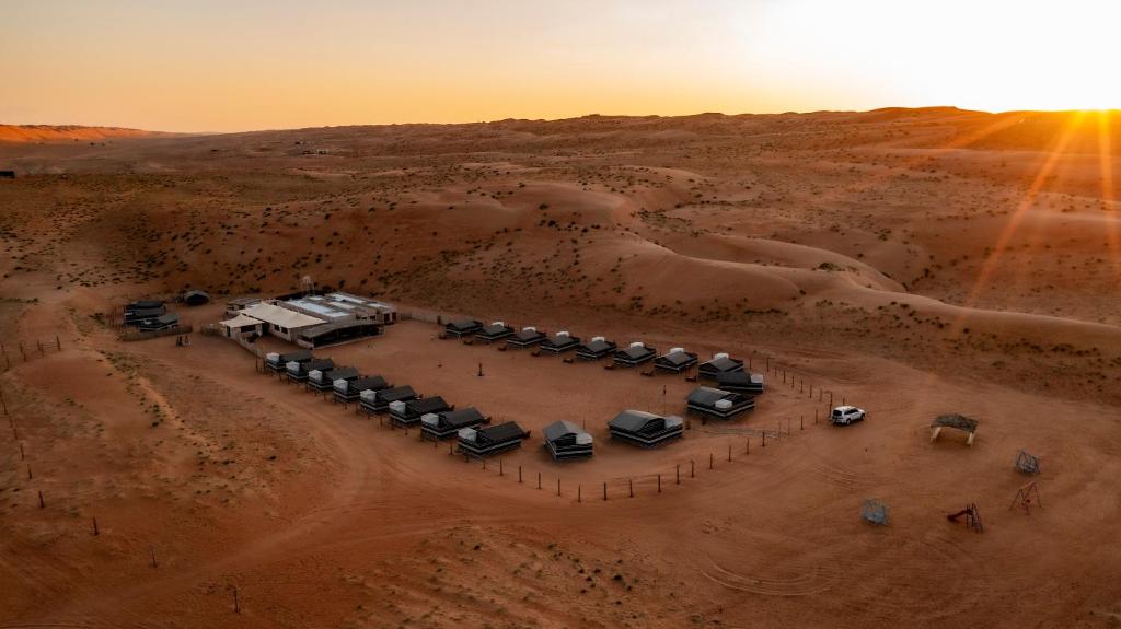 an aerial view of a desert with a group of tents at Sand Delight Camp in Al Wāşil