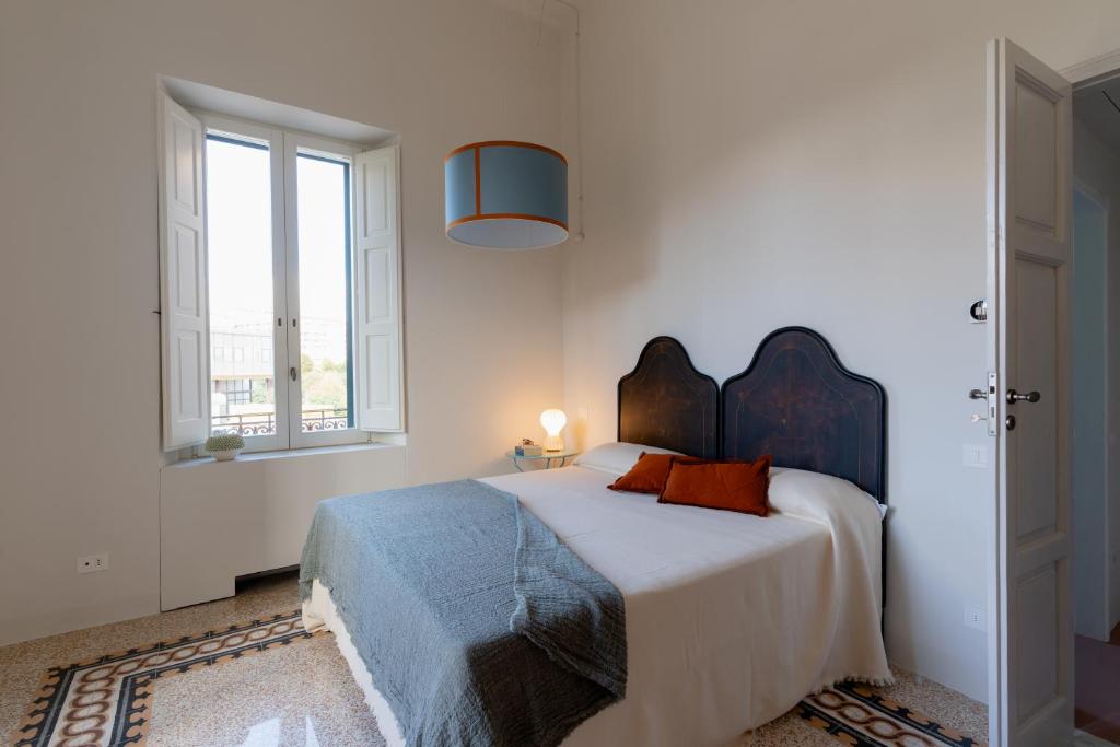 Un dormitorio blanco con una cama grande con una manta azul. en Cappelluti 1924, en Matera