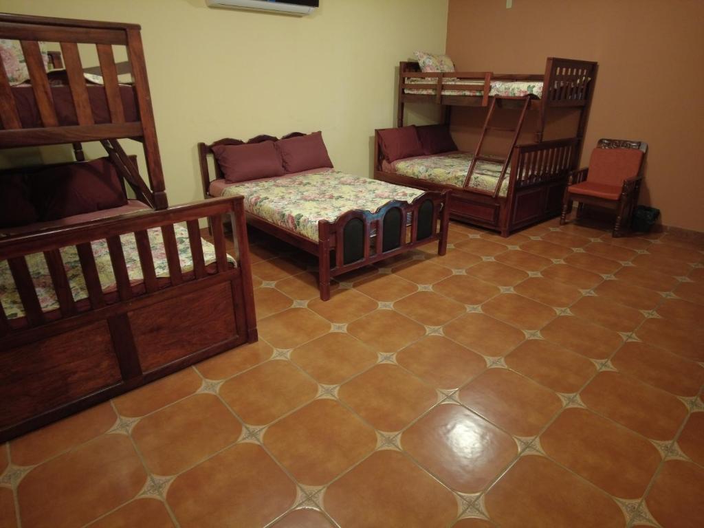 um quarto com três beliches e um sofá em El Castillo de Piedra em San Miguel