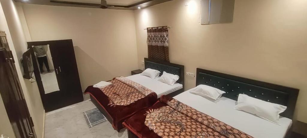 瓦拉納西的住宿－Raghuvanshi Paying Guest House，带两张床和镜子的客房