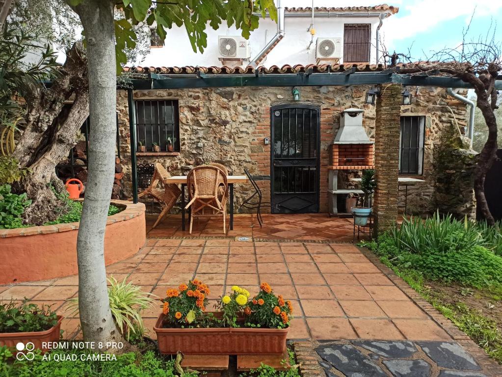 a patio with a table and chairs and a house at El Lucero in Alájar
