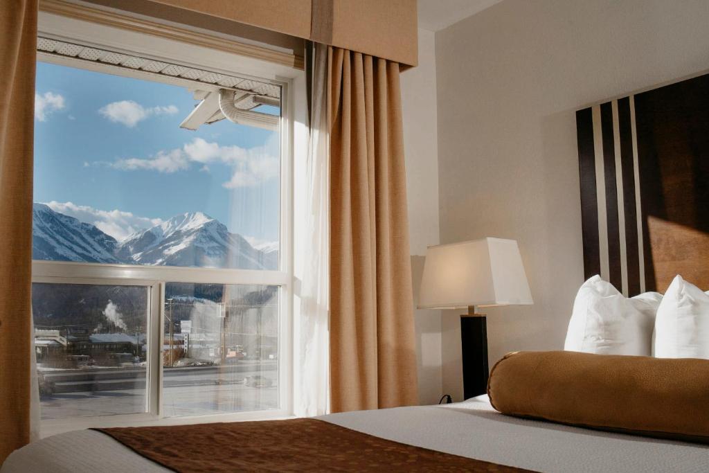 a bedroom with a window with a mountain view at Ramada Golden in Golden