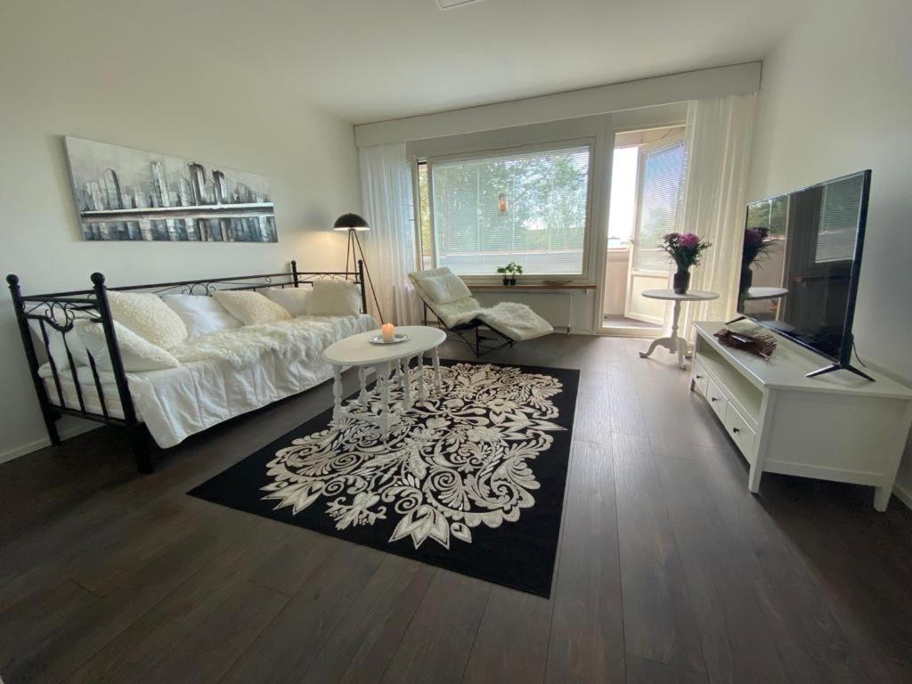 a living room with a bed and a table at Style 1BR Appartment in Kemi - Tornio in Kemi