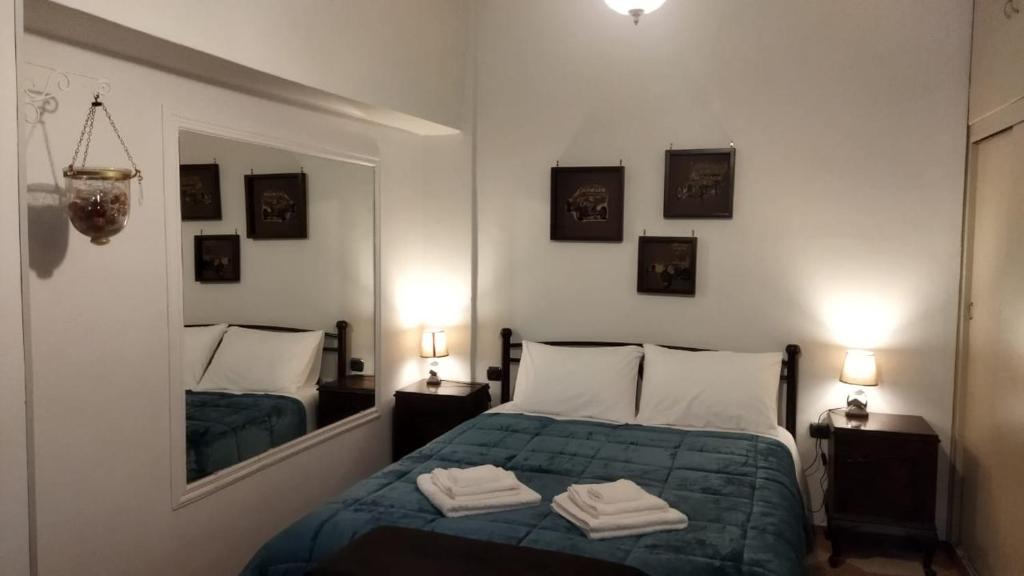 een slaapkamer met een bed met een spiegel en 2 lampen bij Ακαδημία Πλάτωνος in Athene