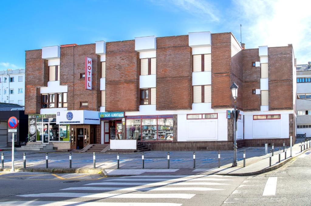 a large brick building on the corner of a street at Hotel Puente de los Santos in Tapia de Casariego