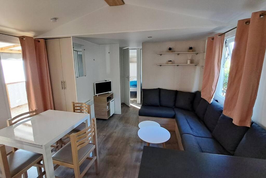 sala de estar con sofá azul y mesa en 490 Emplacement luxe aux Dunes de Contis 3*, en Saint-Julien-en-Born