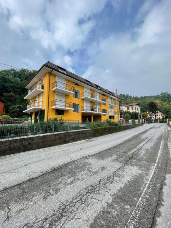 a yellow apartment building on the side of a road at La Garçonniérre del Lago Maggiore in Nebbiuno