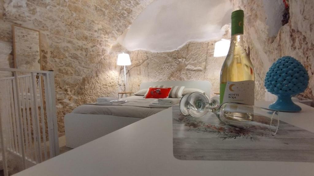 a bottle of wine sitting on a counter next to a bedroom at Cà Giò in Ostuni