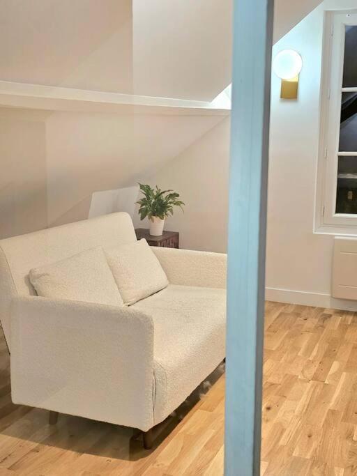 un sofá blanco sentado en una sala de estar en Apartament JO2024, en Maisons-Laffitte