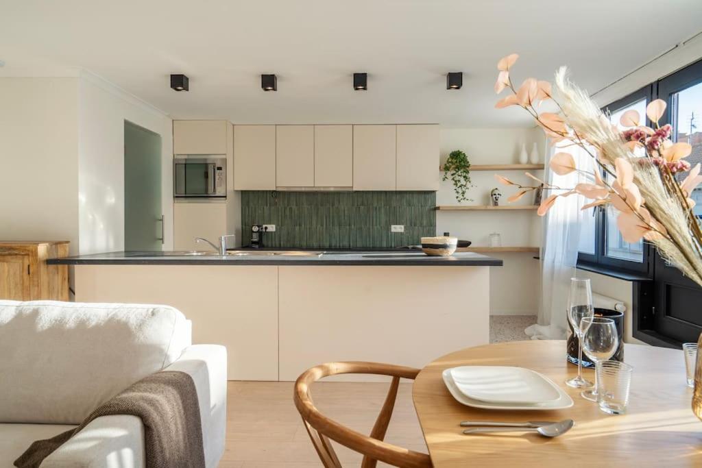 een keuken en een woonkamer met een tafel en een bank bij City Centre Apartment in Kortrijk